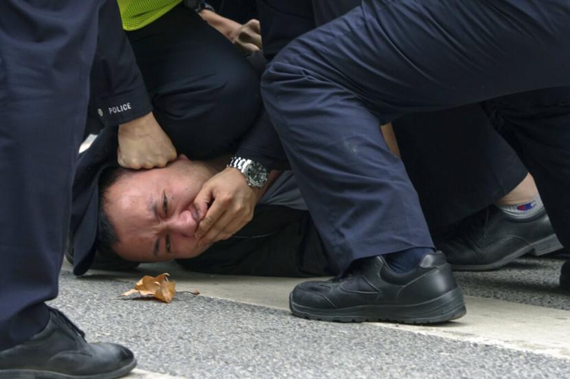  Dalam foto yang diambil pada Minggu, 27 November 2022 ini, polisi menangkap dan menangkap seorang pengunjuk rasa saat protes di sebuah jalan di Shanghai, China. Pihak berwenang melonggarkan aturan anti-virus di daerah-daerah yang tersebar tetapi menegaskan strategi 