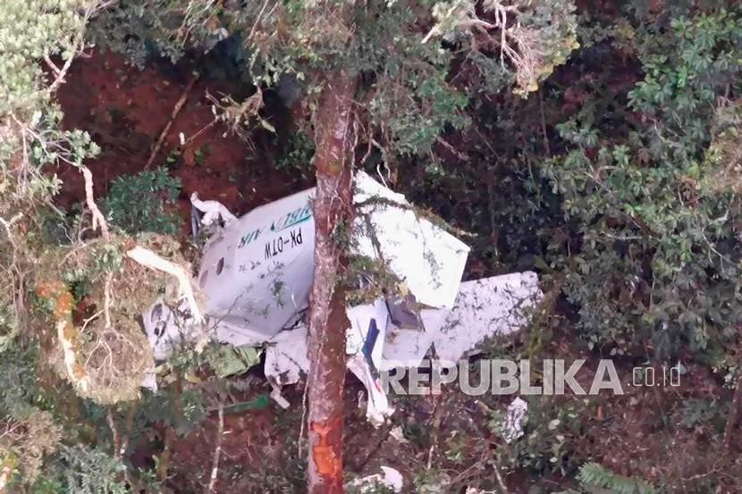  Dalam foto yang dirilis Badan Pencarian dan Penyelamatan Nasional (BASARNAS) ini, puing-puing pesawat kargo kecil Rimbun Air terlihat dari helikopter penyelamat di gunung dekat Intan Jaya, provinsi Papua, Rabu (15/9/2021). Pesawat itu dilaporkan hilang 50 menit setelah lepas landas. 