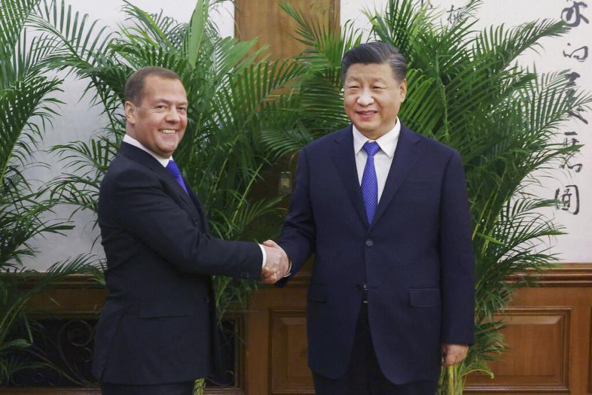 Dalam foto yang dirilis Kantor Berita Xinhua ini, wakil ketua Dewan Keamanan Rusia dan ketua partai Rusia Bersatu, Dmitry Medvedev, kiri, berjabat tangan dengan Presiden China Xi Jinping sebelum pertemuan mereka di Beijing, Rabu, 21 Desember 2022.