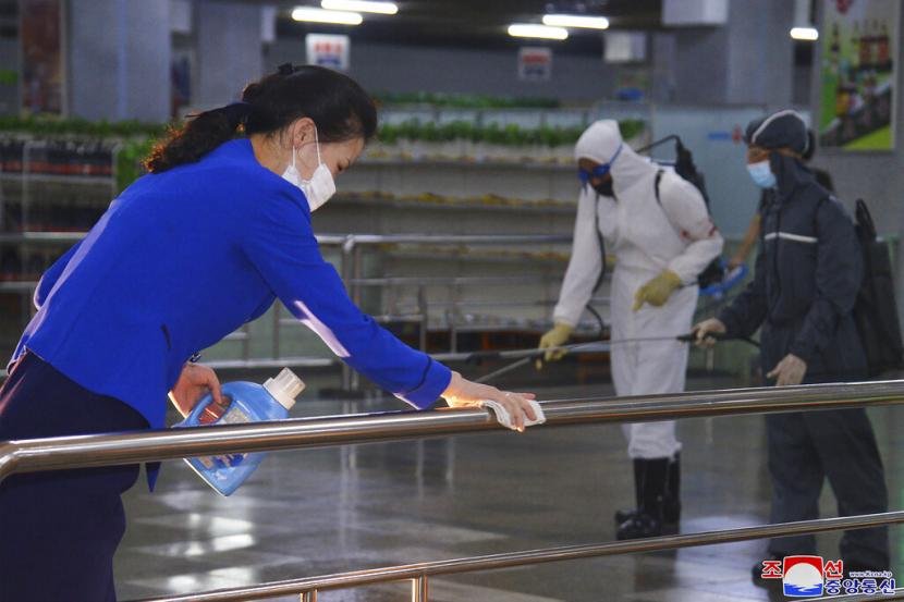 Dalam foto yang diterbitkan pada 28 Juni 2022 oleh pemerintah Korea Utara, karyawan Korea Utara mendisinfeksi fasilitas di toko bawah tanah di Pyongyang, Korea Utara. 