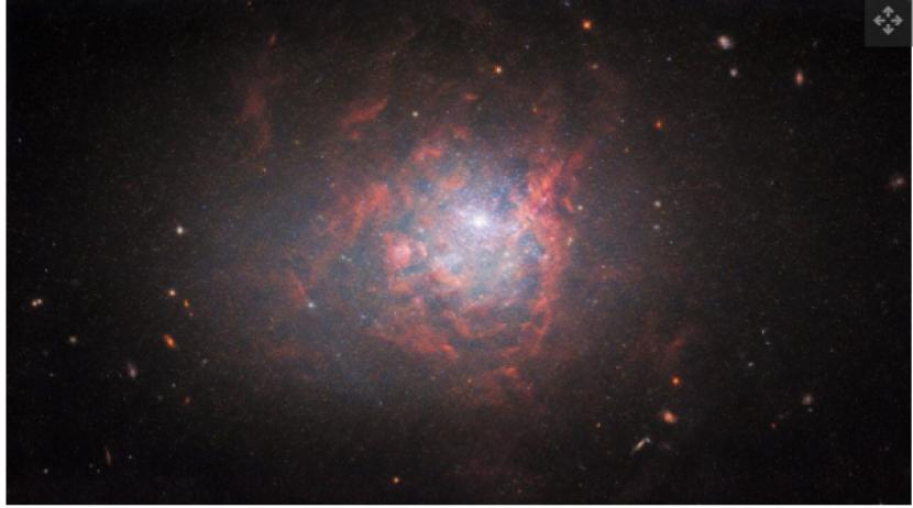 Dalam gambar baru yang diambil oleh Teleskop Luar Angkasa Hubble, galaksi kerdil NGC 1705 bersinar dalam awan cahaya terang dan awan merah.