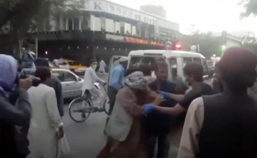 Dalam gambar yang diambil dari video ini, orang-orang merawat orang yang terluka di dekat lokasi ledakan mematikan di luar bandara di Kabul, Afghanistan, Kamis, 26 Agustus 2021.