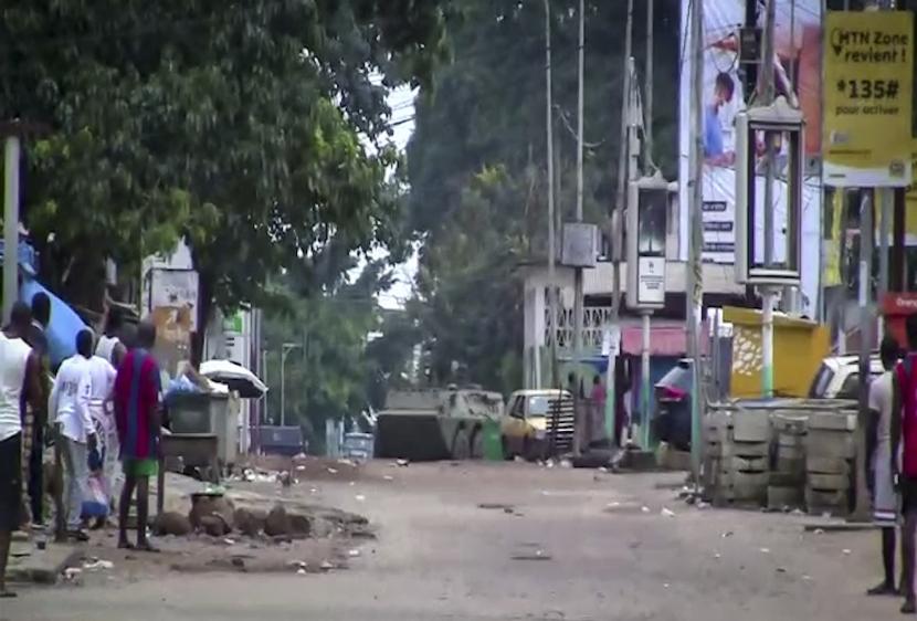 Dalam gambar yang diambil dari video ini, warga menyaksikan pengangkut personel lapis baja terlihat di jalan-jalan dekat istana presiden di ibu kota Conakry, Guinea, Minggu, 5 September 2021.