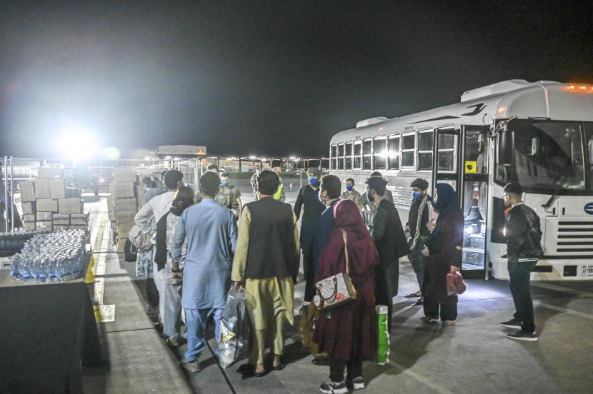 Dalam gambar yang disediakan oleh Angkatan Udara AS, sekelompok pengungsi Afghanistan berangkat dari bus di Pangkalan Udara Ramstein, Jerman, Jumat, 20 Agustus 2021. 