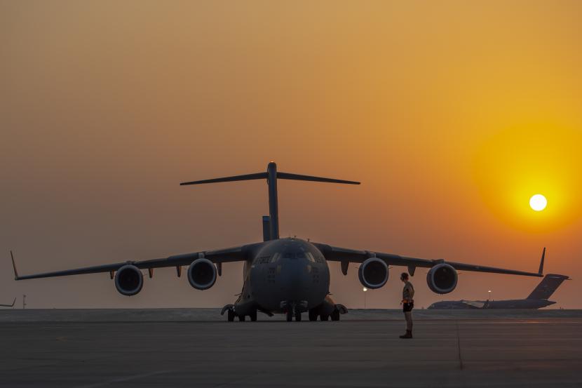  Dalam gambar yang disediakan oleh Angkatan Udara AS ini, seorang anggota dari Sayap Ekspedisi Udara ke-379 bersiap untuk mengerahkan C-17 Globemaster lll sebagai taksi C-17 lainnya ke jalur penerbangan 23 Agustus 2021, di Pangkalan Udara Al Udeid, Qatar. 