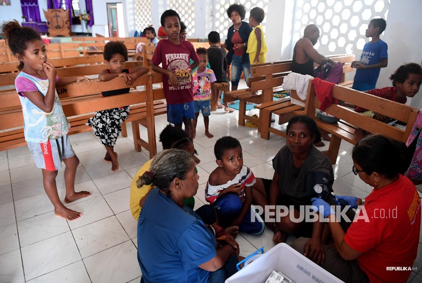 Dampak Banjir Bandang Sentani. Anggota Basarnas bersama petugas kesehatan memeriksa kondisi warga yang mengungsi akibat banjir bandang Sentani di sekitar Danau Sentani, Sentani, Jayapura, Papua, Selasa (19/3/2019).