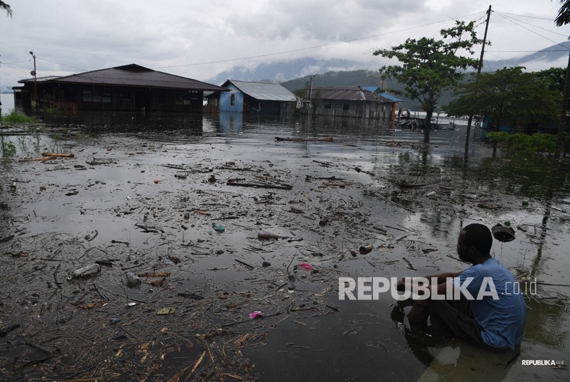 Dampak Banjir Bandang Sentani. Seorang warga mengamati permukiman tempat tinggalnya yang terendam banjir bandang di sekitar Danau Sentani di Jayapura, Papua, Selasa (19/3/2019). 