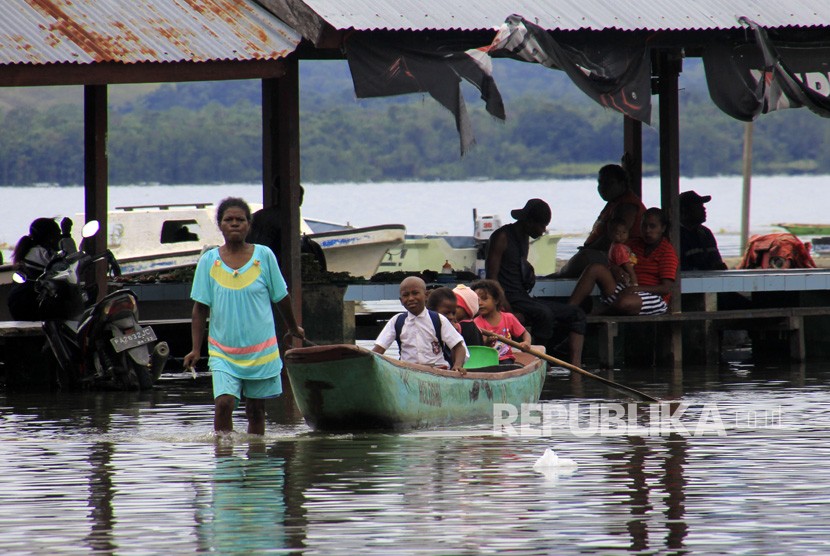 Danau Sentani Meluap. Sejumlah siswa menaiki perahu melintasi banjir akibat luapan Danau Sentani di Yahim, Sentani Tega, Kabupaten Jayapura, Papua, Senin (11/3/2019). 