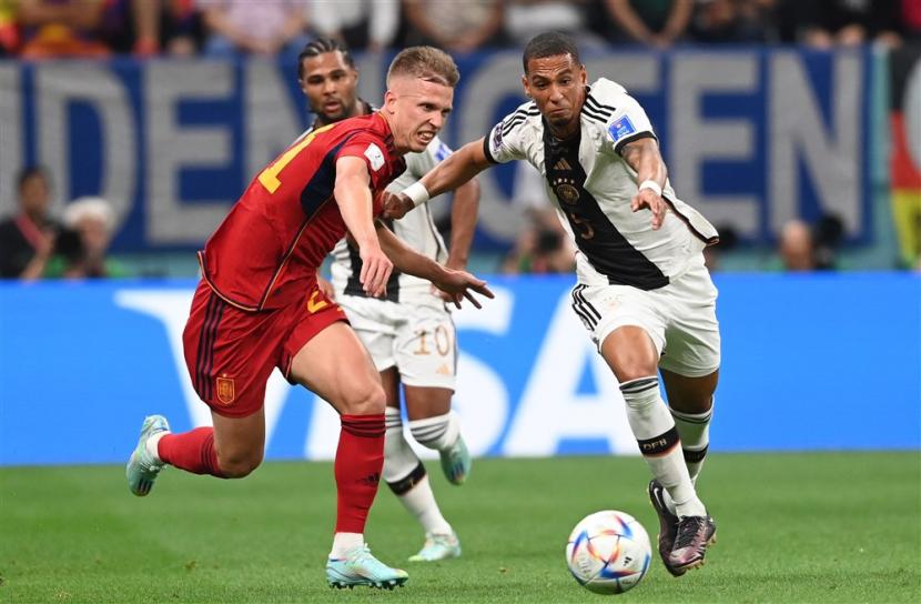  Dani Olmo (Kiri) dari Spanyol beraksi melawan Thilo Kehrer dari Jerman selama pertandingan sepak bola grup E Piala Dunia 2022 antara Spanyol dan Jerman di Stadion Al Bayt di Al Khor, Qatar, Senin (28/11/2022) dini hari WIB.