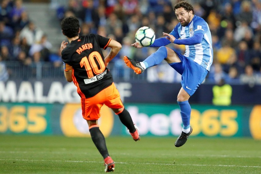 Daniel Parejo berebut bola dengan pemain Malaga Manuel Ittura (kanan). 