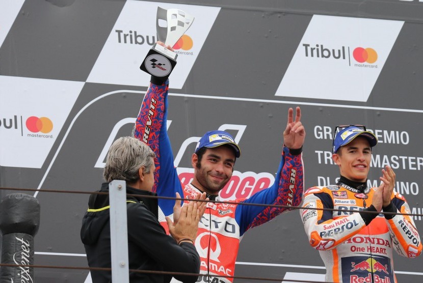Danilo Petrucci (tengah) dan Marc Marquez di podium MotoGP di Misano, San Marino, Ahad (10/9).