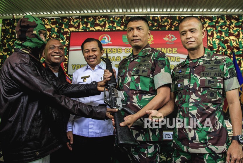 Danrem 172/Praja Wira Yakti (PWY) Kolonel Inf J Binsar P Sianipar (kedua kanan) disaksikan Komandan Satgas Yonif Para Raider 328/Dirgahayu Mayor Inf Erwin Iswari (kanan), Wakil Wali Kota Jayapura Rustan Saru (tengah) serta Kepala Administrator PLBN Skouw Yan Numberi (kedua kiri) menerima senjata dari anggota Organisasi Papua Merdeka (OPM) di Skouw, Distrik Muara Tami, Jayapura, Papua, Sabtu (25/1/2019).