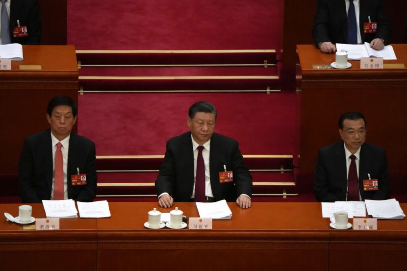 Dari kiri, Li Zhanshu, Presiden China Xi Jinping, dan Perdana Menteri Li Keqiang menghadiri sesi pembukaan Kongres Rakyat Nasional (NPC) Tiongkok di Aula Besar Rakyat di Beijing, Minggu, 5 Maret 2023.
