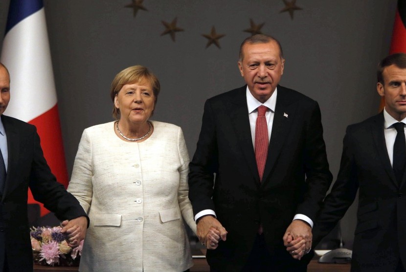  Dari kiri, Presiden Rusia Vladimir Putin, Kanselir Jerman Angela Merkel, Presiden Turki Recep Tayyip Erdogan, dan Presiden Prancis Emmanuel Macron berpose di akhir konferensi pers setelah pertemuan puncak KTT Suriah, di Istanbul, Turki, Sabtu (27/10).