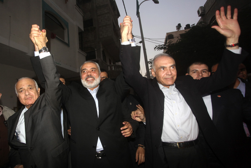 Dari kiri : Sekjen Liga Arab Nabil Elaraby,Perdana Menteri Palestina Ismail Haniyeh dan Menteri Luar Negeri Mesir Mohammed Kamel Amr, melambaikan tangan saat kunjungan di Kota Gaza, Selasa (20/11). (AP/Ashraf Amra)