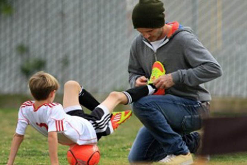 Seorang ayah mengajari anaknya taktik main bola. (Ilustrasi)