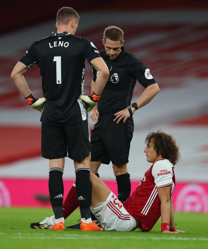David Luiz (kanan) terduduk akibat mengalami cedera saat tampil memperkuat Arsenal melawan Leicester di Stadion Emirates, Senin (26/10).