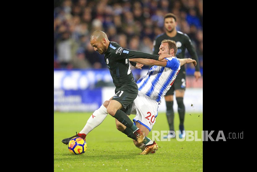 David Silva (kiri) Laurent Depoitre (kanan) beraksi pada pertandingan Liga Inggris antara Huddersfiled Town melawan Manchester City di John Smith's Stadium, Huddersfield, Inggris.