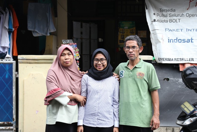  Dea Mandasari (tengah), salah satu mahasiswa baru Universitas Gadjah Mada (UGM) yang berhasil masuk tanpa tes, diapit kedua orangtuanya. 