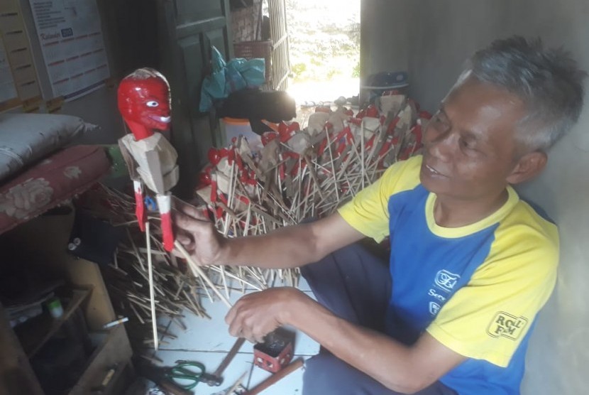Dede yang akrab disapa Dede Wayang tengah memproduksi wayang mainan cepot dan yang lainnya di rumahnya di Kampung Babakan Garut, Desa Mekarsari, Kabupaten Bandung Barat, Rabu (12/5).