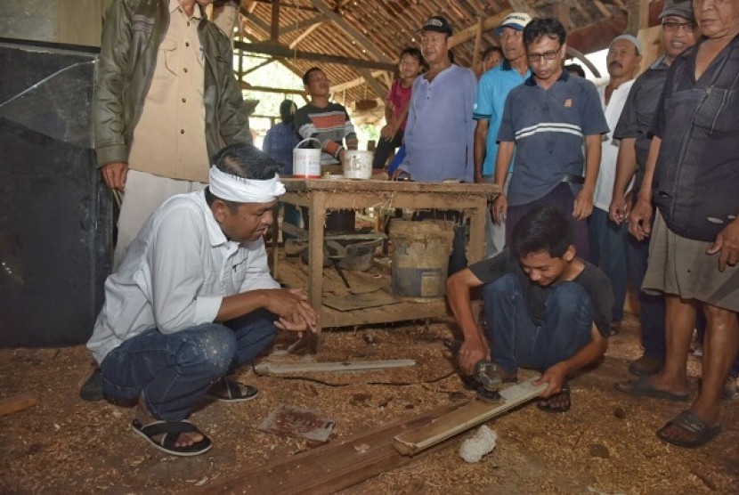 Dedi Mulyadi melihat pelajar yang tengah menggerinda kayu di Desa Karangpatri, Kecamatan Pebayuran, Kabupaten Bekasi, Rabu (7/3).