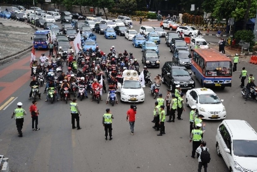 Demo pemotor tolak pelarangan sepeda motor melewati Jalan MH Thamrin di Bundaran HI, Jakarta, Senin (22/12). 
