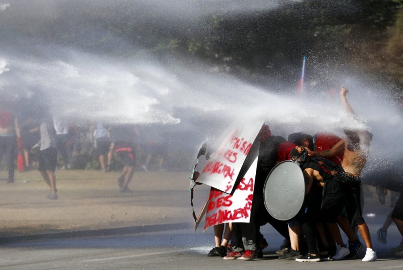 Demonstran antipemerintah disemprot water cannon oleh polisi di Santiago, Cile, Jumat (15/11).