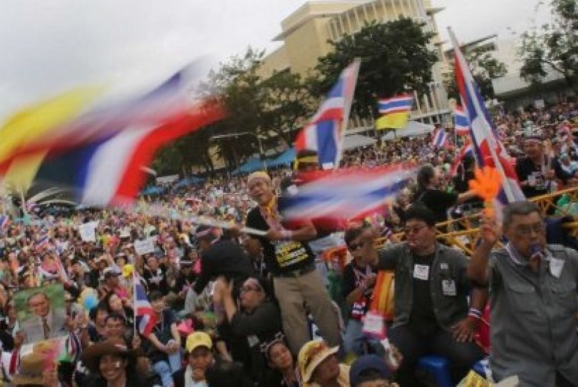 Demonstran antipemerintah melambaikan bendera Thailand, menuntut PM Yingluck Shinawatra mundur dari jabatannya.