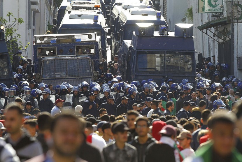 Demonstran dan polisi antihuru-hara dalam protes menuntut lengsernya Presiden Aljazair Abdelaziz Bouteflika di Aljir, Aljazair, 29 Maret 2019. 