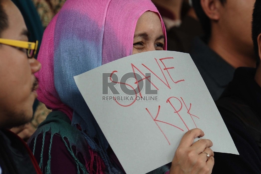 Demonstran dari Koalisi Masyarakat Sipil Anti Korupsi melakukan aksi simpatik di halaman kantor Komisi Pemberantasan Korupsi (KPK), Jakarta, Jumat (23/1).   (Republika/Tahta Aidilla)