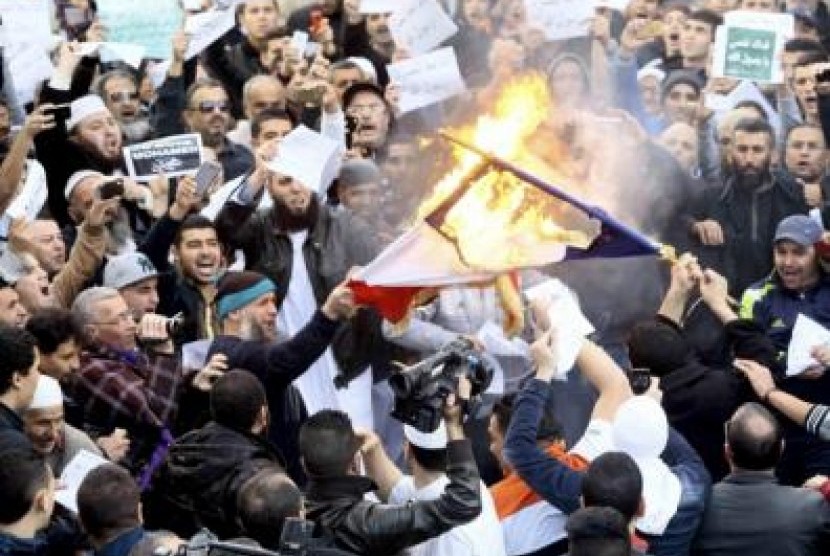 Demonstran di Aljazair membakar bendera Prancis usai shalat Jumat (17/1). Aksi tersebut merupakan bentuk protes terhadap Charlie Hebdo yang menerbitkan edisi terbaru dengan kartun Nabi Muhammad.