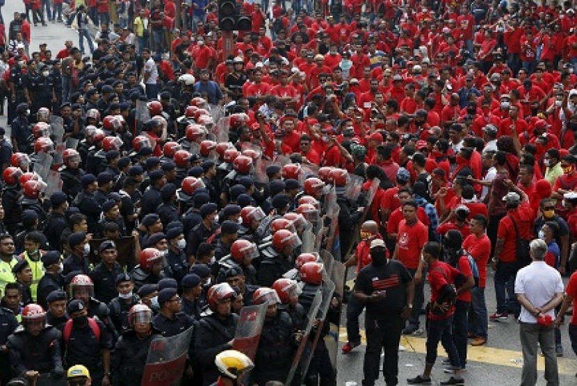 Demonstran kaos merah berhadapan dengan aprat Malaysia, Rabu (18/9).