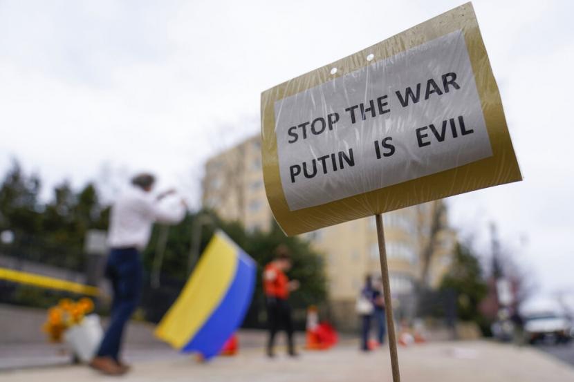Demonstran melakukan aksi di depan Kedutaan Rusia di Washington membawa poster dengan tulisan 
