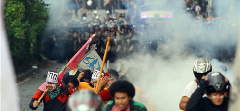 Demonstran melarikan diri saat polisi menembakkan gas air mata ketika melakukan aksi demonstrasi menolak kenaikan harga BBM di depan gedung DPR/MPR, Senayan, Jakarta. 