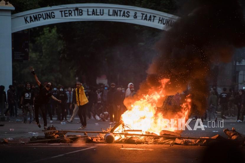 Demonstran melempar batu saat unjuk rasa menolak UU Cipta Kerja di Kota Bandung, Jawa Barat, Rabu (7/10).