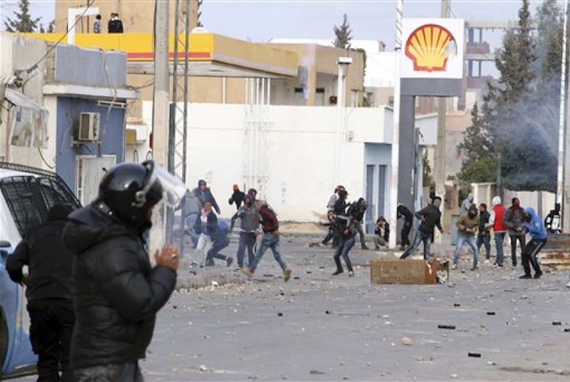 Demonstran melempari polisi di Kota Ennour dekat Kasserine, Tunisia, Rabu, 20 Januari 2016. Tunisia memberlakukan jam malam akibat protes yang meluas.