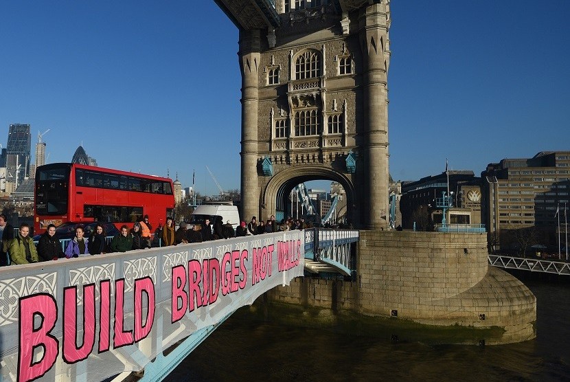 Demonstran memasang banner bertuliskan 'Build Bridges not Walls' di Tower Bridge London, Inggris, dalam aksi protes terhadap pelantikan Donald Trump. 