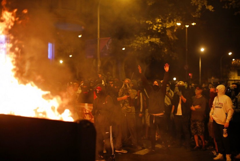 Demonstran membakar barikade di Barcelona, Spanyol, Sabtu (19/10). Demonstran memprotes sembilan pemimpin separatis yang dipenjara.