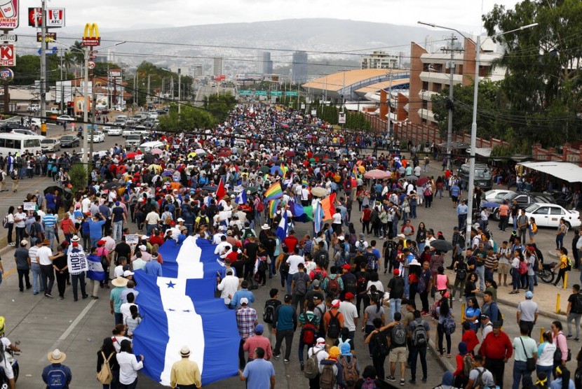 Demonstran membawa bendera Honduras saat melakukan aksi protes menuntut Presiden Juan Orlando Hernandez mundur di Tegucigalpa, Honduras, Selasa (6/8).