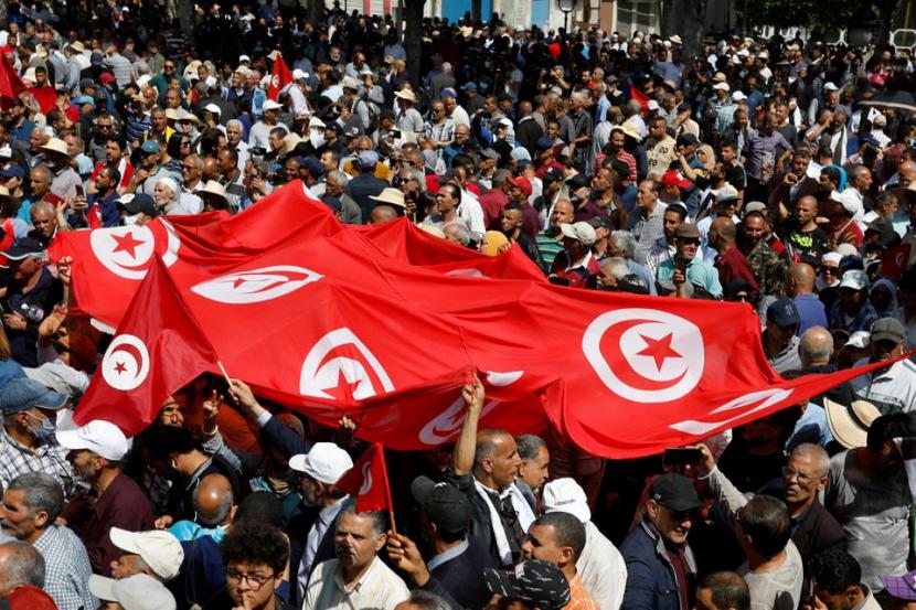 Demonstran membawa spanduk dan bendera selama protes terhadap Presiden Tunisia Kais Saied di Tunis, Tunisia, 15 Mei 2022. Protes di Tunisia di Tengah Inflasi dan Kekurangan Pangan