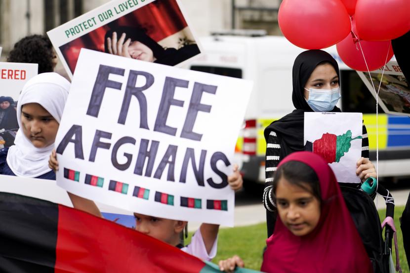 Demonstran memegang plakat, selama protes di Parliament Square, London, Rabu, 18 Agustus 2021. Pemerintah Inggris mengatakan pihaknya berencana untuk menerima 5.000 pengungsi Afghanistan tahun ini, terutama wanita dan anak-anak, sebagai tanggapan atas perebutan kekuasaan oleh Taliban.