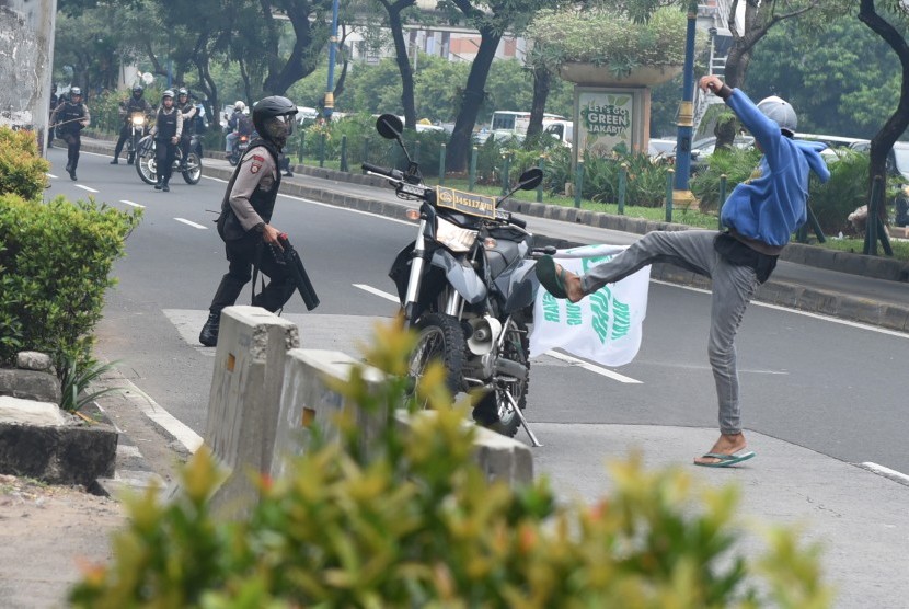 Demonstran menendang motor polisi saat kericuhan yang terjadi pada unjuk rasa di depan Gedung KPK, Jakarta, Jumat (20/5). (Antara/Hafidz Mubarak A)