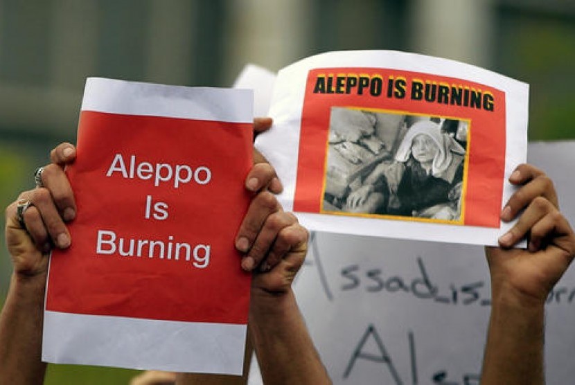 Demonstran mengacungkan poster saat berunjuk rasa di depan Markas PBB di Beirut, Lebanon, Ahad, 1 Mei 2016. Mereka menentang operasi militer di wilayah yang dikuasai pemberontak, dengan Aleppo menjadi pusatnya.