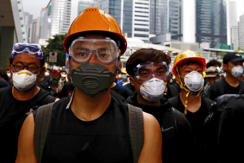 Demonstran mengenakan kacamata pelindung dan masker berjalan menuju Dewan legislatif untuk melanjutkan protes menentang RUU ekstradisi di Hong Kong, Senin (17/6).