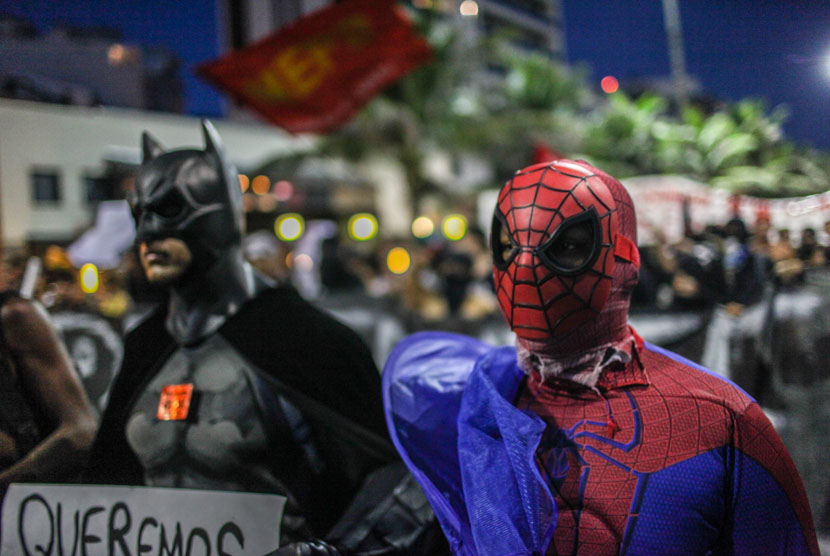 Demonstran mengenakan karakter super hero dalam melakukan aksi demonstrasi menentang Piala Dunia 2014 di Rio de Janeiro, Brasil.