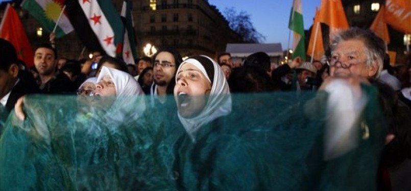 Demonstran menggelar aksi unjuk rasa di Balai Kota Paris, Paris, Kamis (15/3), untuk mendukung rakyat Suriah dalam perayaan satu tahun perlawanan mereka terhadap rezim pemerintahan Bashar al-Assad. 