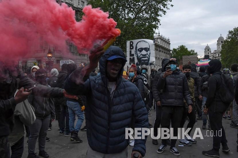 Demonstran menyalakan suar selama aksi protes Black Lives Matter di London, Inggris, Ahad (7/6). Aksi tersebut sebagai tanggapan atas pembunuhan George Floyd oleh petugas polisi di Minneapolis, AS, yang telah menyebabkan protes di banyak negara dan di seluruh dunia.  