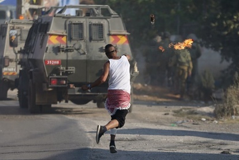 Demonstran Palestina melempar bom molotov ke militer Israel, Sabtu (1/8). 