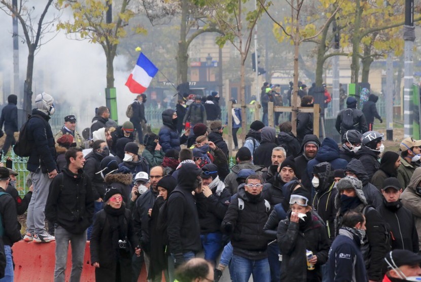 Demonstran rompi kuning dalam peringatan pertama gerakan tersebut di Paris, Sabtu (16/11). Protes rompi kuning berujung bentrok dengan polisi.