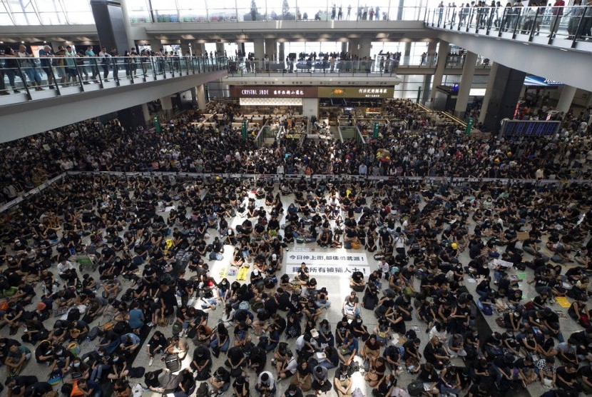 Demonstran saat melakukan aksi duduk di terminal kedatangan di Bandara Internasional Hong Kong, Hong Kong, Senin (12/8). Semua penerbangan yang tersisa dibatalkan. 